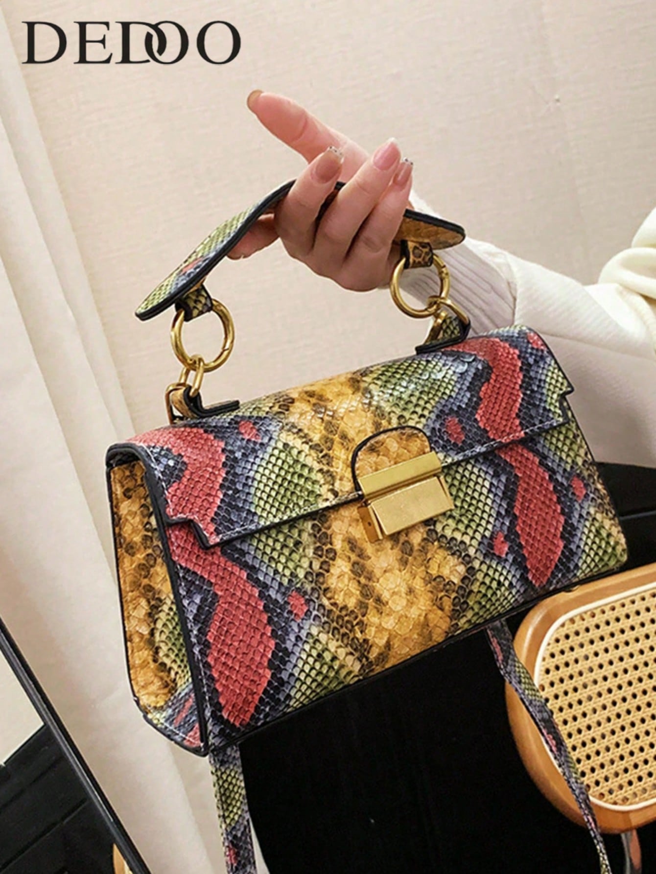 Interior Design High End - 洗練された高級感のある素材、上品なラグジュアリー感、蛇柄の個性的なデザイン、多様な用途に対応できるハンドバッグ、取り外し可能なショルダーストラップ、脇にかけるタイプのロック。